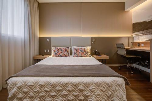 a bedroom with a bed and a desk and a piano at Rio Hotel by Bourbon Campinas in Campinas