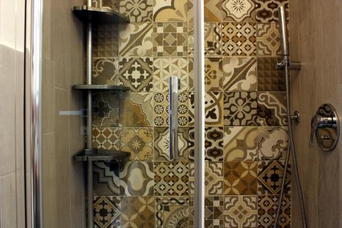 a bathroom with a shower with a tiled wall at [Appartamento Centro Storico] Da nonna Maria ☆☆☆☆☆ in Procida