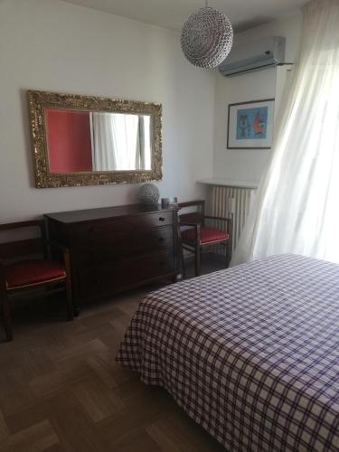 een slaapkamer met een bed, een dressoir en een spiegel bij CASA SIMONE in Porto San Giorgio