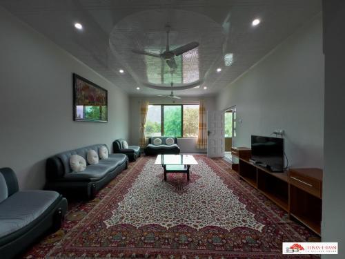 a living room with a couch and a tv at Ehsan-e-Bassi in Gilgit