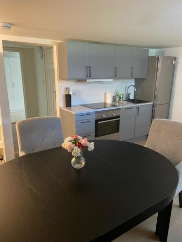 eine Küche mit einem Tisch und einer Blumenvase darauf in der Unterkunft Modern appartment in classic house, close to beach and city center in Kristiansand