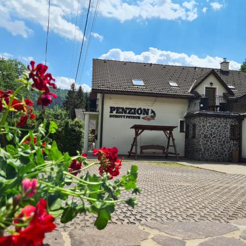 a building with a sign on the side of it at Penzión Dúhový Pstruh in Bystrá