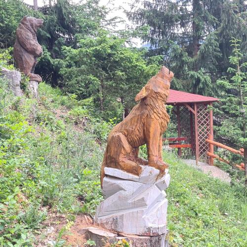 a statue of a bear standing on a stump at Penzión Dúhový Pstruh in Bystrá