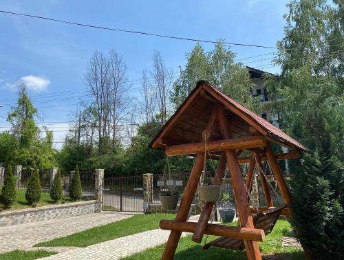 una pequeña estructura de madera en un patio en Vila San Nicoara en Curtea de Argeş