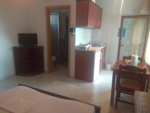 een kleine keuken met een wastafel en een aanrecht bij Simos Apartments in Korinós
