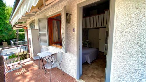 a balcony with a table and chairs and a bed at Residence Al Lago in Castiglione del Lago
