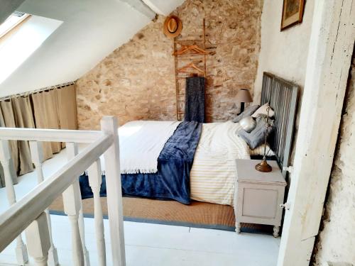 a bedroom with a bed in a stone wall at Charmante maisonnette en duplex au pied du Château in Nogent-le-Rotrou