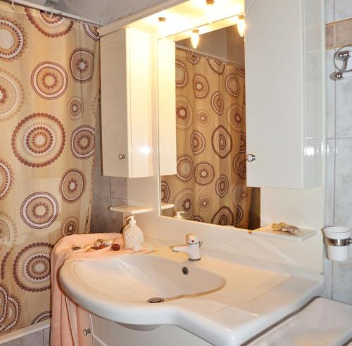 a bathroom with a sink and a mirror at Theodora in Patitiri