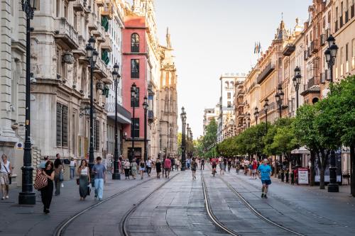 a group of people walking down a city street at BYPILLOW Abril in Seville