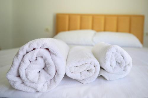 una pila di asciugamani appoggiata sopra un letto di Vila S&S a Vlorë