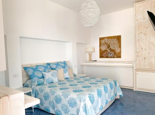 a bedroom with a bed with a blue and white comforter at Nonna Pasqualina in Panarea