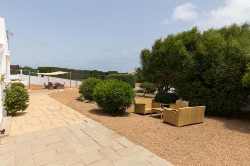a patio with couches and bushes and trees at Holiday Home - Son Vida in Mahón