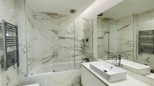 a white bathroom with a sink and a shower at Prime by Check-in Portugal in Albufeira