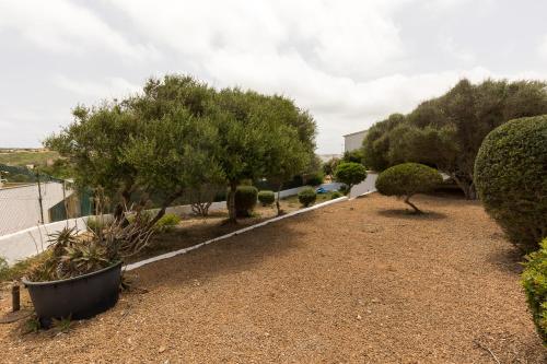 a garden with trees and bushes and a road at Holiday Home - Son Vida in Mahón