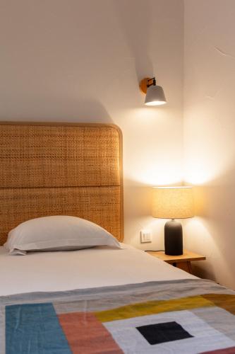 a bedroom with a bed and a lamp on a table at Hôtel l'Arena in Fréjus