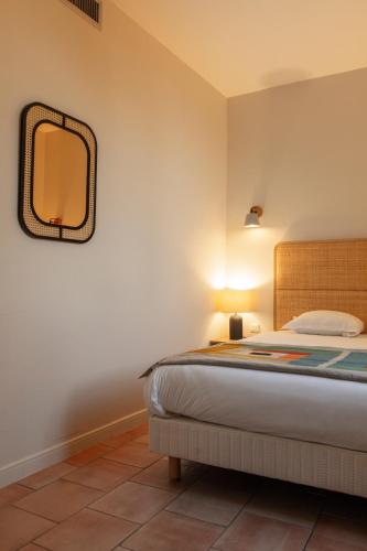 a bedroom with a bed and a mirror on the wall at Hôtel l'Arena in Fréjus