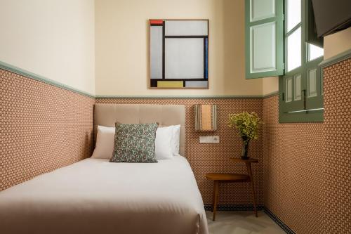 a bedroom with a bed and a mirror and a window at BYPILLOW Abril in Seville