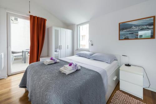 a bedroom with a bed with towels on it at Dubrovnik Apartments Lele in Dubrovnik