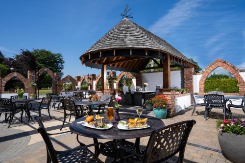 a patio with tables and chairs and a gazebo at Burrendale Hotel Country Club & Spa in Newcastle