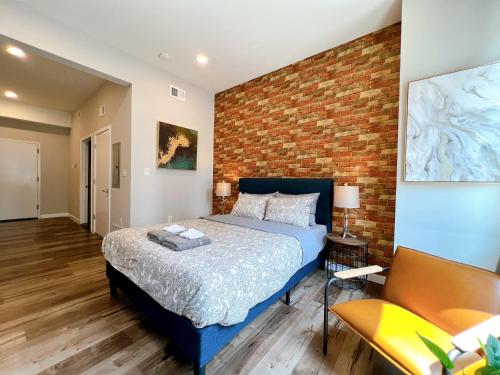 a bedroom with a bed and a brick wall at Stay at Luna on Ridge Ave in Philadelphia