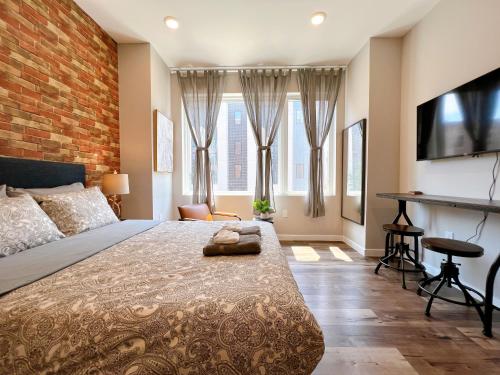 a bedroom with a large bed and a brick wall at Stay at Luna on Ridge Ave in Philadelphia