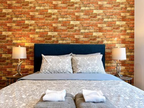 a bedroom with a bed and a brick wall at Stay at Luna on Ridge Ave in Philadelphia