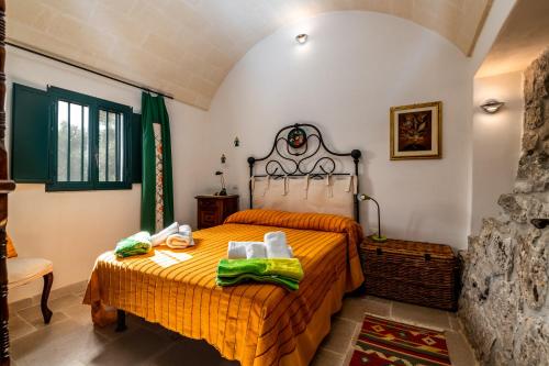 1 dormitorio con 1 cama con colcha de color naranja en Trullo Maria Teresa, en San Vito dei Normanni