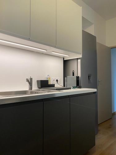 a kitchen with black cabinets and a white counter top at Villa des Thermes - T3 in Royat