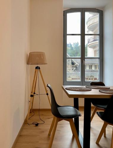 Cette chambre comprend un bureau avec une chaise et une lampe. dans l'établissement Villa des Thermes - T3, à Royat