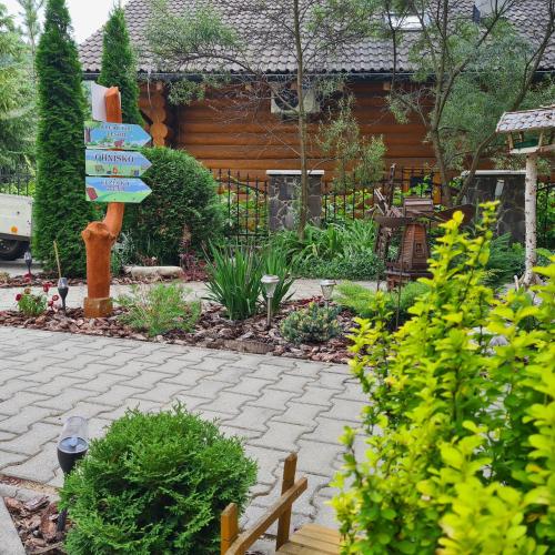 a garden with a sign and some plants at Penzión Dúhový Pstruh in Bystrá