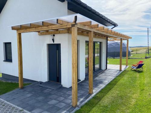a pergola on a patio of a house at Domek Delux -komfortowe apartamenty, domki w Ojcowskim Parku Narodowym Z Jaccuzi in Wola Kalinowska
