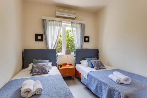 two beds in a bedroom with towels on them at Villa Aggeliki by Villa Plus in Pírgos Psilonérou