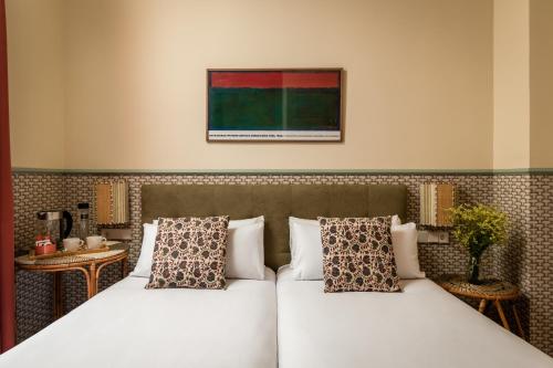 two beds in a hotel room with at BYPILLOW Abril in Seville