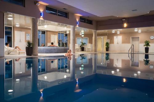 a swimming pool in a building with people in the background at Burrendale Hotel Country Club & Spa in Newcastle