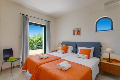 a bedroom with two beds with towels on them at Villa Anni by Villa Plus in Pírgos Psilonérou