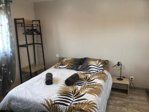 a bed with black and white sheets and pillows at Appartement neuf avec jardin privatif in Périgueux