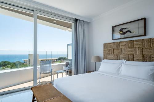 a bedroom with a bed and a large window at Apartamentos Marivent by Brava Hoteles in Platja d'Aro