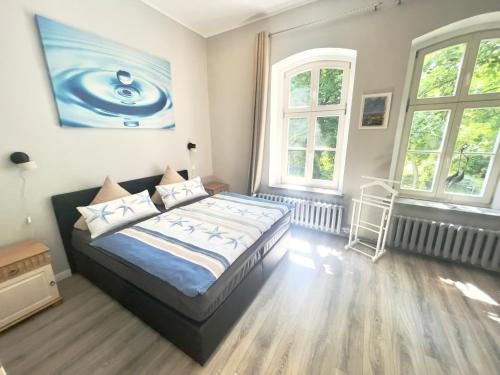 ein Schlafzimmer mit einem Bett und zwei Fenstern in der Unterkunft Leichtmatrose - Sternschanze in Stralsund