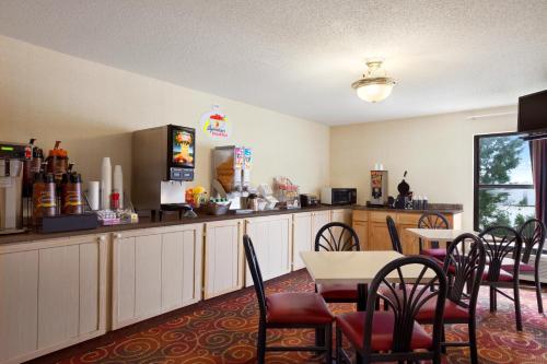 a restaurant with a table and chairs and a kitchen at Super 8 by Wyndham Evansville North in Warrenton