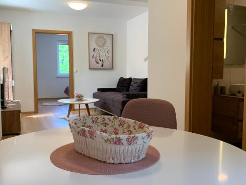 una sala de estar con una mesa con un tazón. en Apartmaji Prʼ nas en Laško