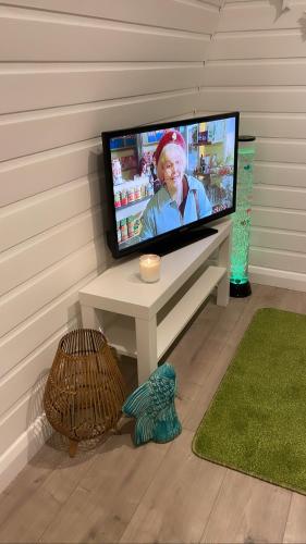 a flat screen tv sitting on a table in a room at Paddock Pod - Sleeps 4 & Roofed Over Private Hot Tub & NEW SAUNA in Burnfoot