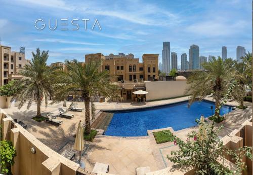 ドバイにあるYansoon by Emaar, Downtown Dubaiのヤシの木と建物のあるプールの景色を望めます。