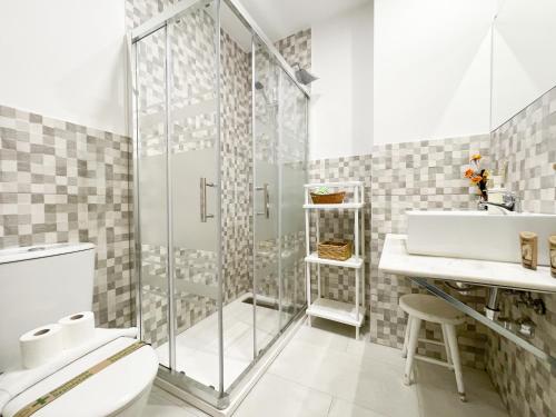 a bathroom with a shower and a toilet and a sink at San Marcos Apartamentos in Seville