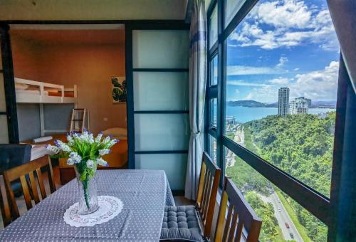a vase of flowers on a table in a room with a view at Lavender Homes @ Jesselton Quay Kota Kinabalu in Kota Kinabalu