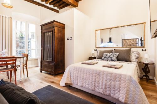 a bedroom with a large bed and a dining room at Il nido in centro in Lucca