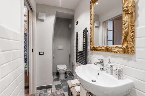 Baño blanco con lavabo y espejo en Il nido in centro, en Lucca