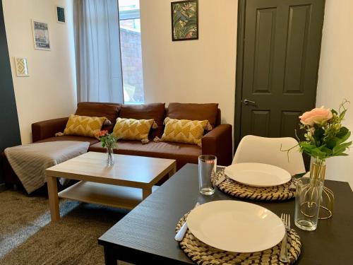 uma sala de estar com um sofá e duas mesas em Lovely 1 bedroom, 4 guests service apartment em Doncaster