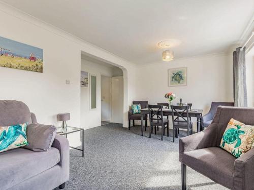 a living room with a couch and chairs and a table at Lovely Magnolia Apartment 6 single beds in Torquay