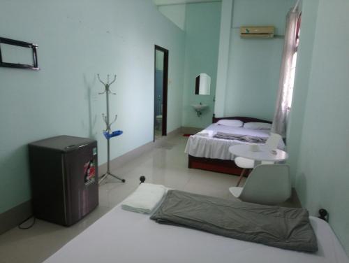 a bedroom with a bed and a table and a desk at Hoa Lan in Cao Lãnh