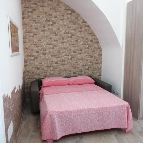 - une chambre avec un lit et un mur en briques dans l'établissement Dimora Genovesi, à Catane